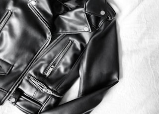 black leather zip-up jacket on white textile