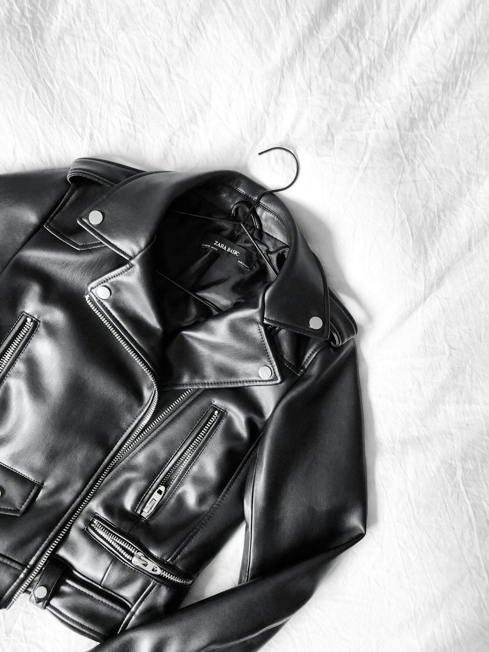 Veste zippée en cuir noir sur textile blanc