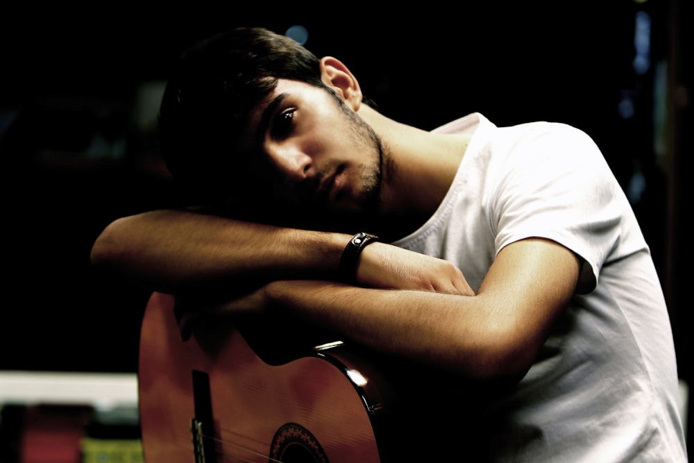 man holding brown acoustic guitar