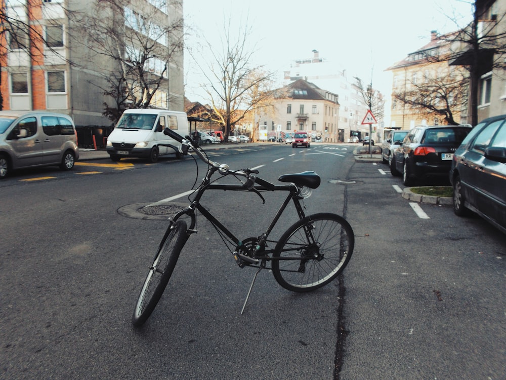 black bicycle parked in middle of street