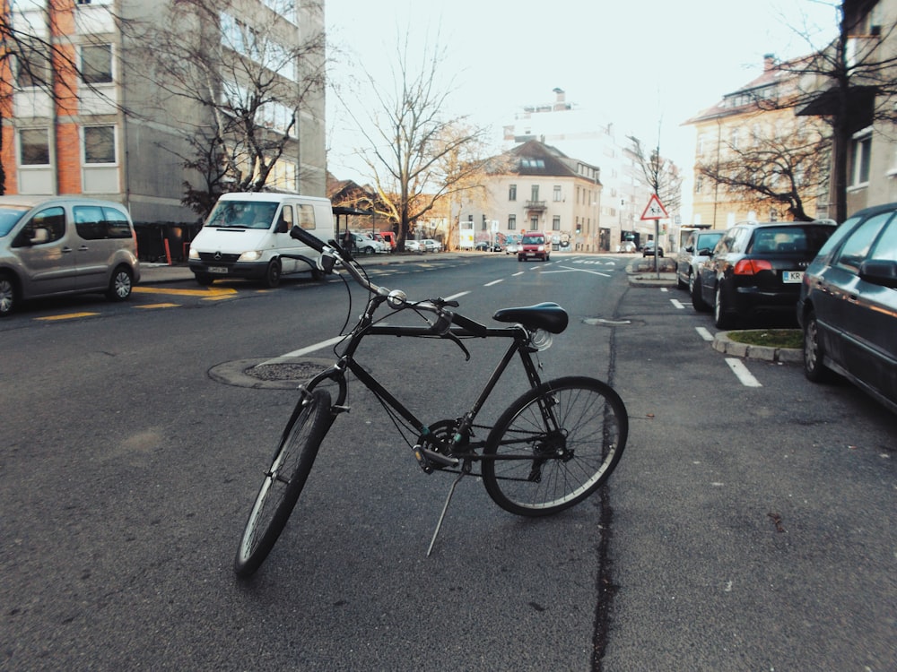 Bicicleta preta estacionada no meio da rua