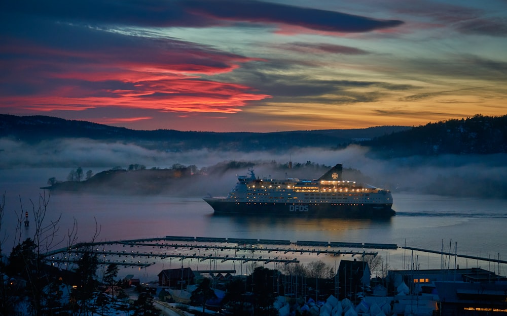 white cruise ship on body of water during dusk
