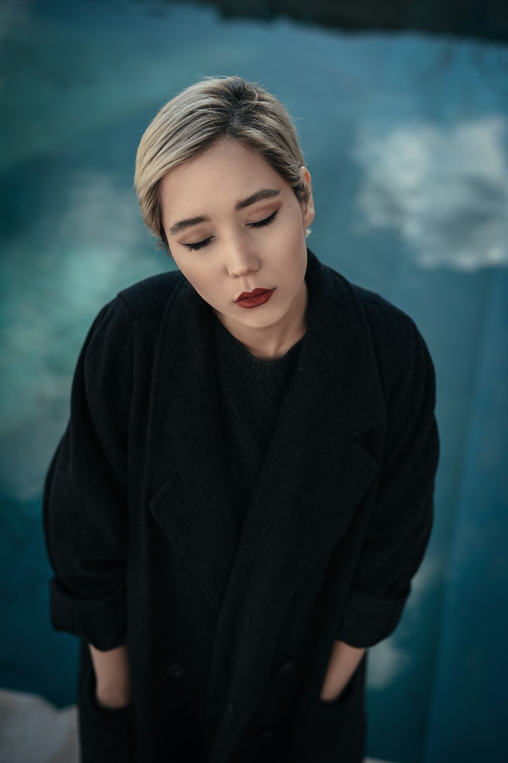 woman in black dress stands with hands in pocket