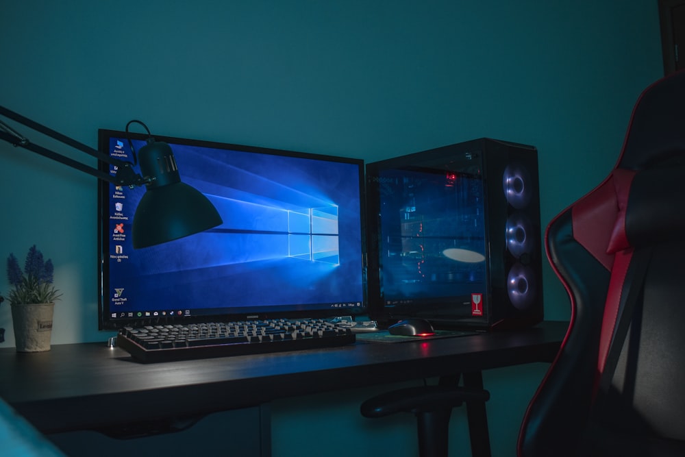 Ensemble d’ordinateur de bureau allumé avec fauteuil de jeu en cuir noir et gris