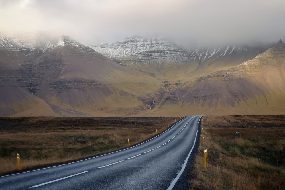 gray concrete road and brown mountains during daytime