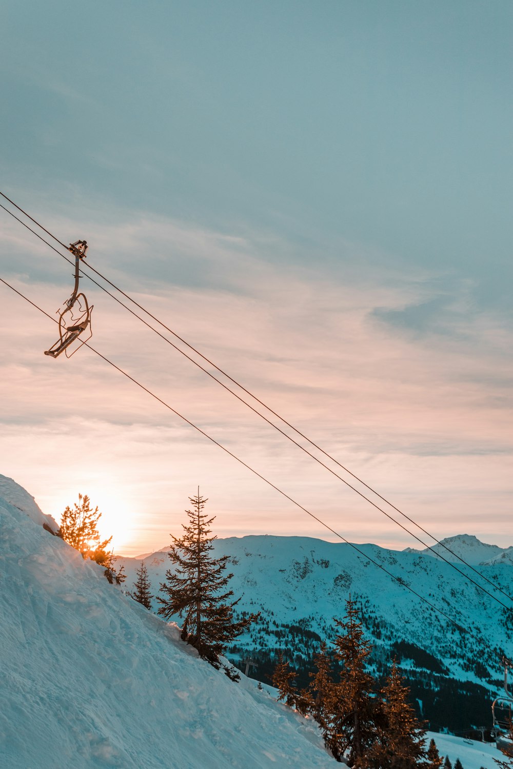Skilift die naar beneden gaat met zonsondergang op de achtergrond