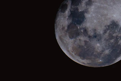 Close-up of the moon's craters under a clear starry night.