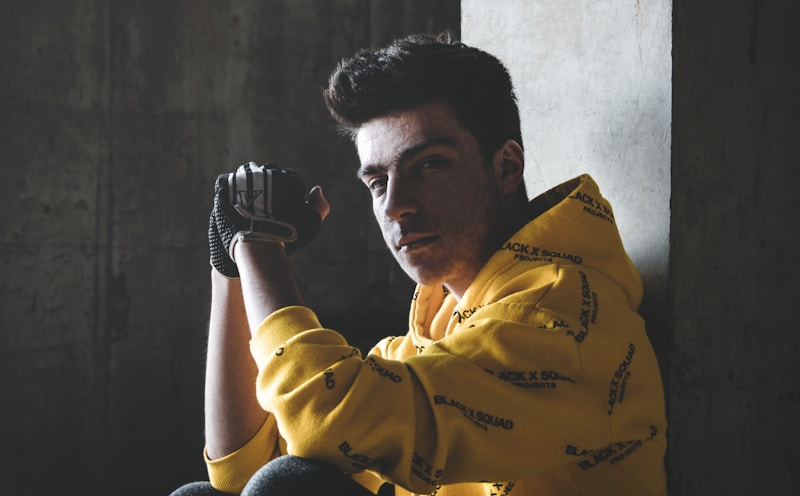 selective focus photography of man wearing yellow-and-black hoodie