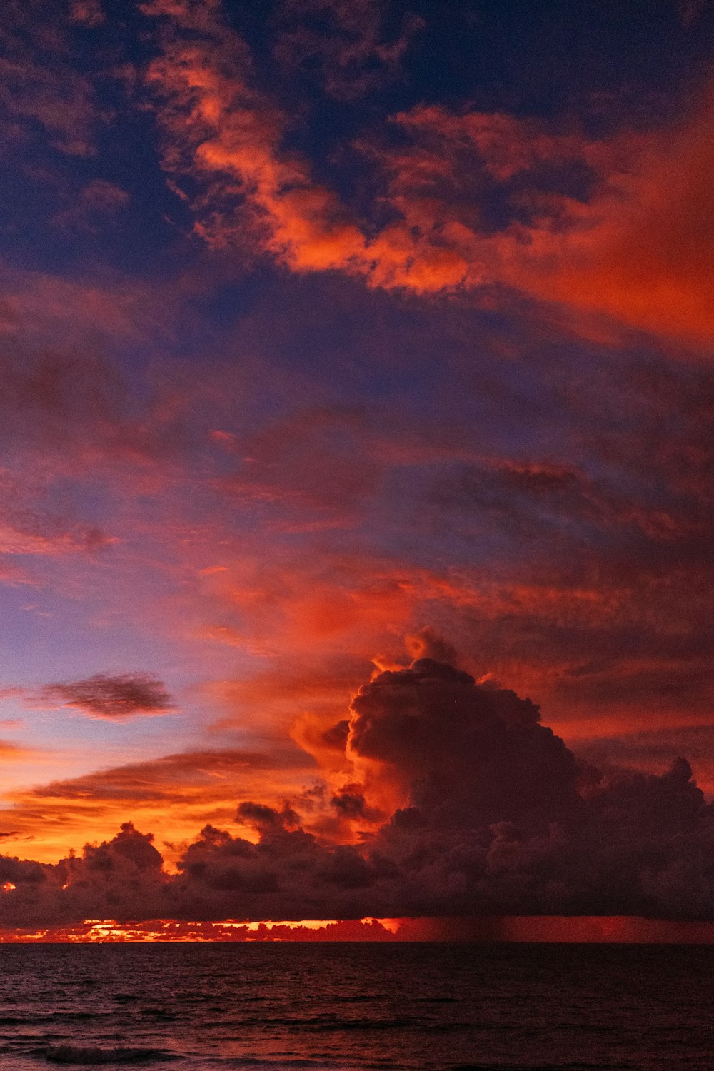 ocean under orange colored clouds