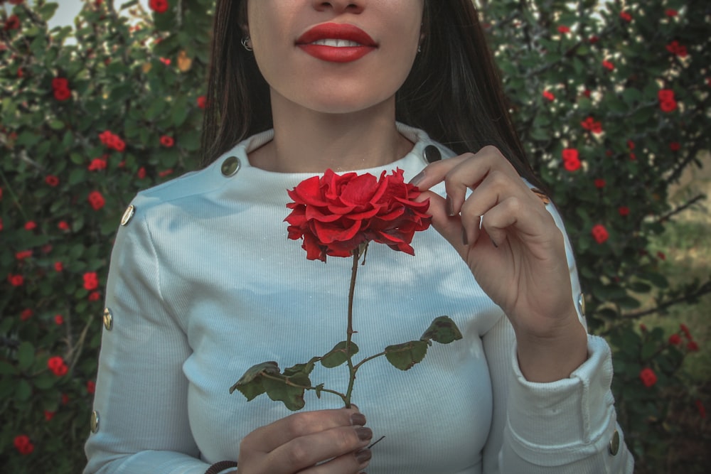 donna che tiene il fiore rosso