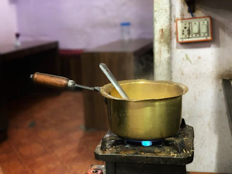 Hands stirring a pot on a vintage stove, steam rising gently.