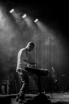 A pianist performing passionately on stage under soft lighting.