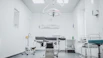 An operating room with a surgical table, overhead light, and medical equipment