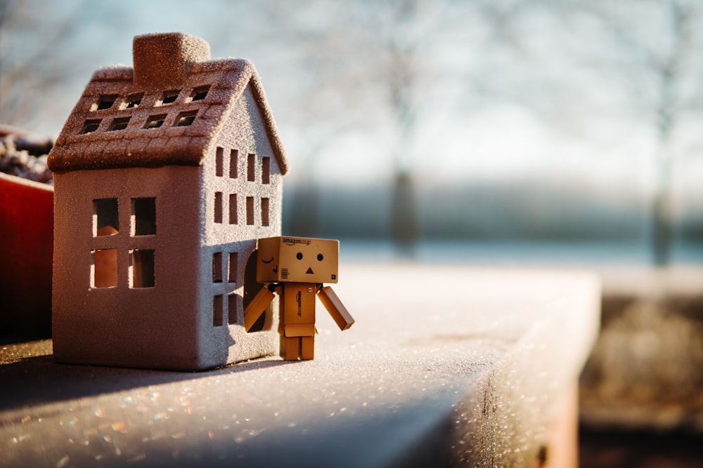 brown wooden house miniature on brown surface