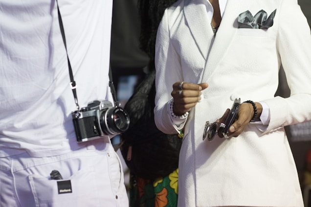 A stylish black and white photo showcasing a man and woman dressed in elegant luxury clothing accented with gold accessories.