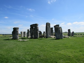 Tourists exploring the ancient stones of Stonehenge on a sunny day.