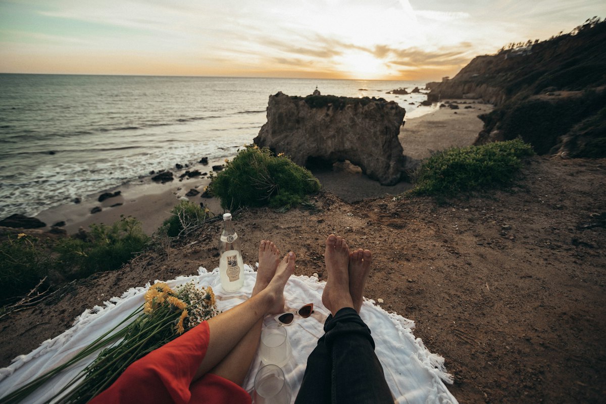 Couple watching sunset from water villa deck