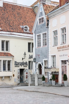 A charming street in a French city showing renovated classic buildings with fresh facades and lively storefronts.