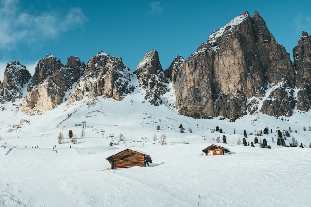 brown cabin surrounded by snow near snow-capped mountains