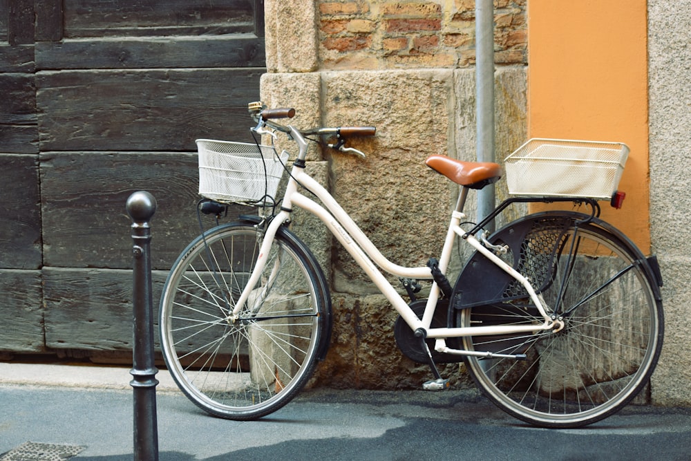white commuter bike leaning on wall