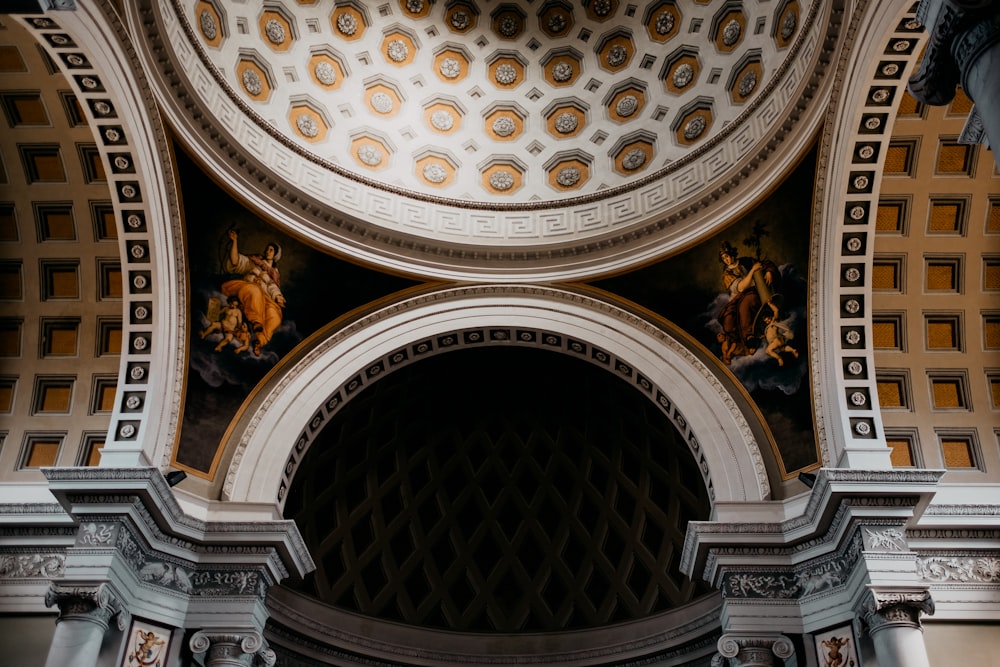 the ceiling of a building with statues on it