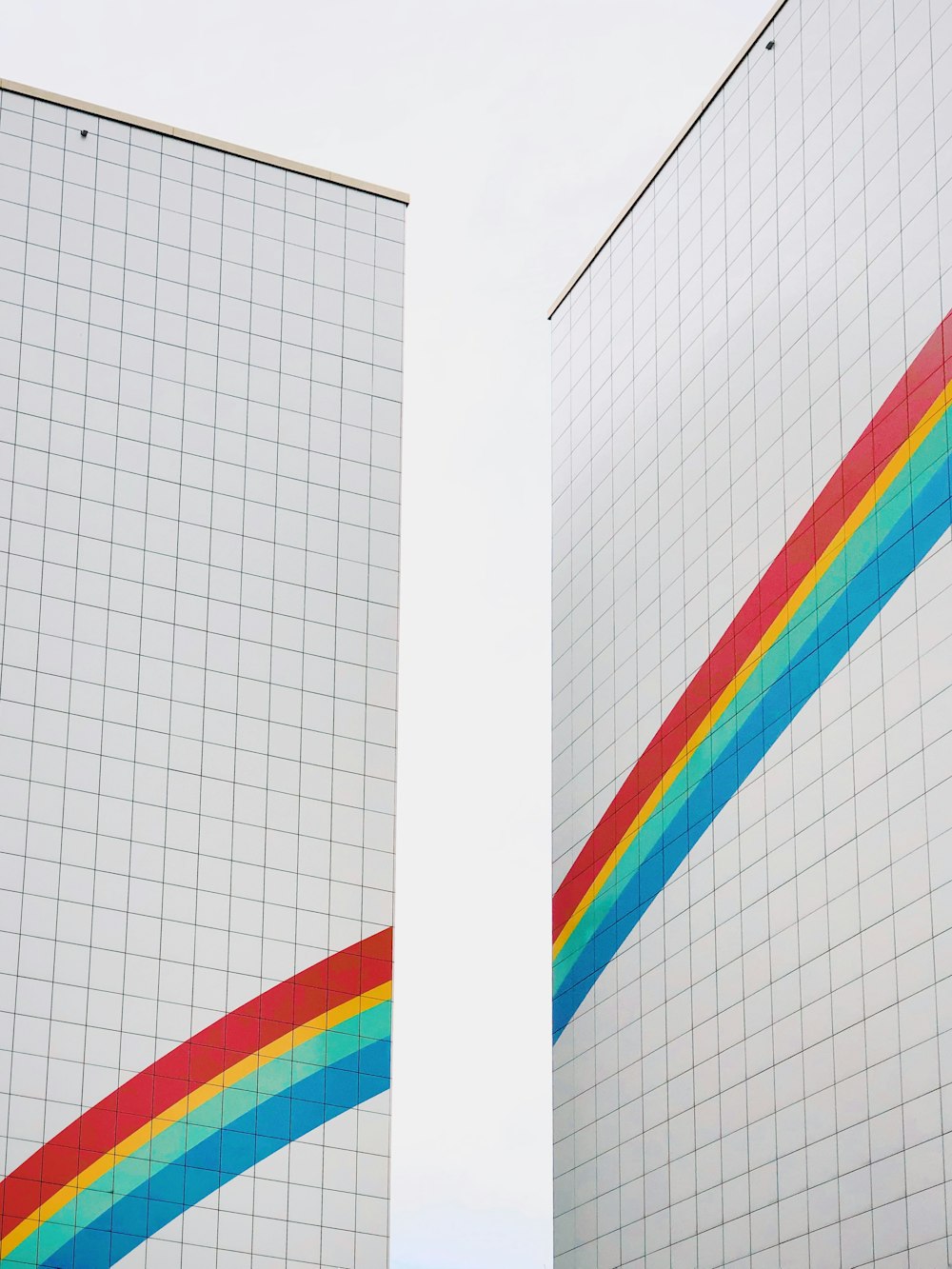 Dos edificios blancos con pintura de arco iris