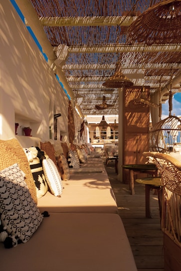 A cozy outdoor seating area featuring a weather-resistant rug with vibrant patterns under a wooden pergola.