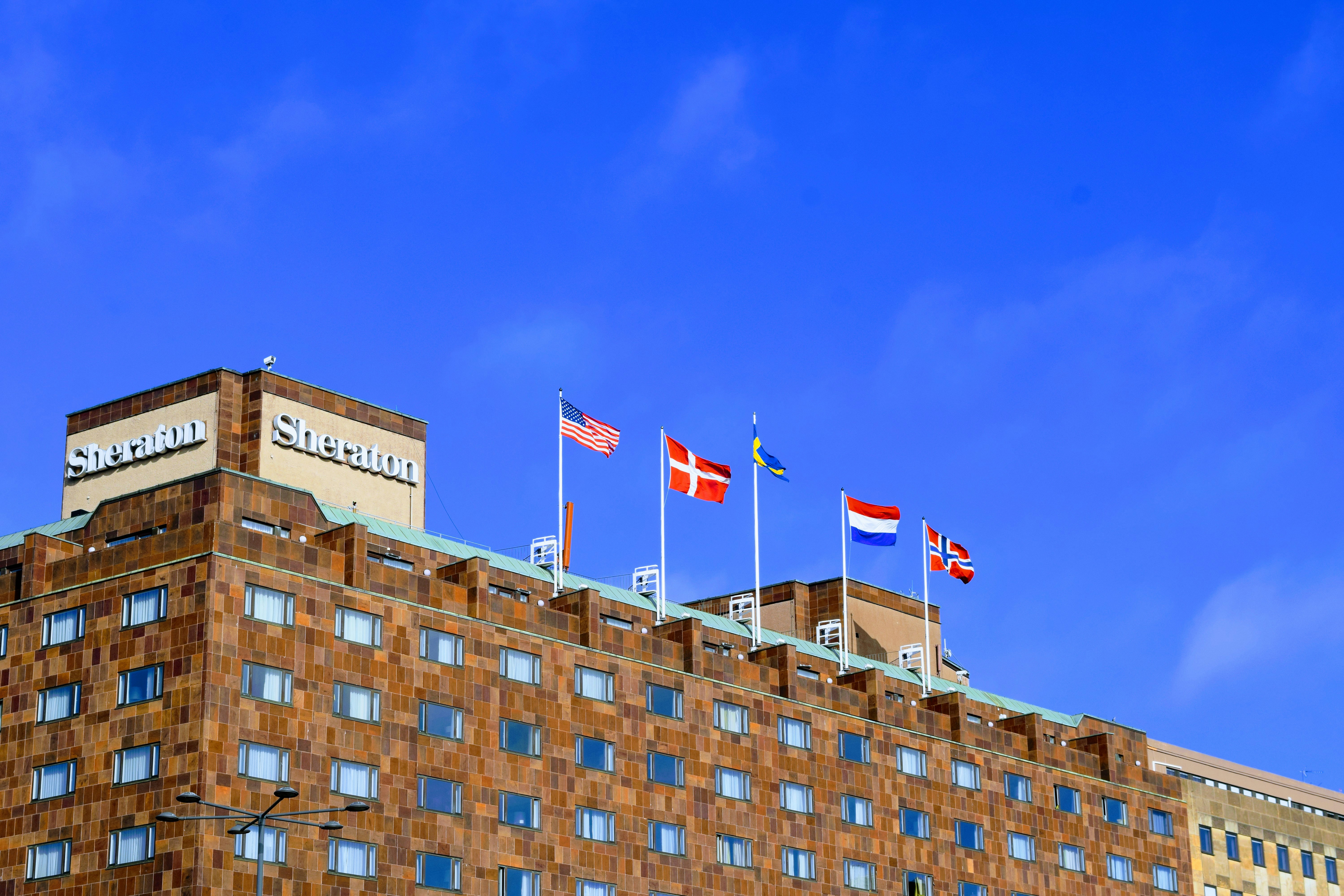 brown concrete building under clear blue sky, Sheraton Hotel