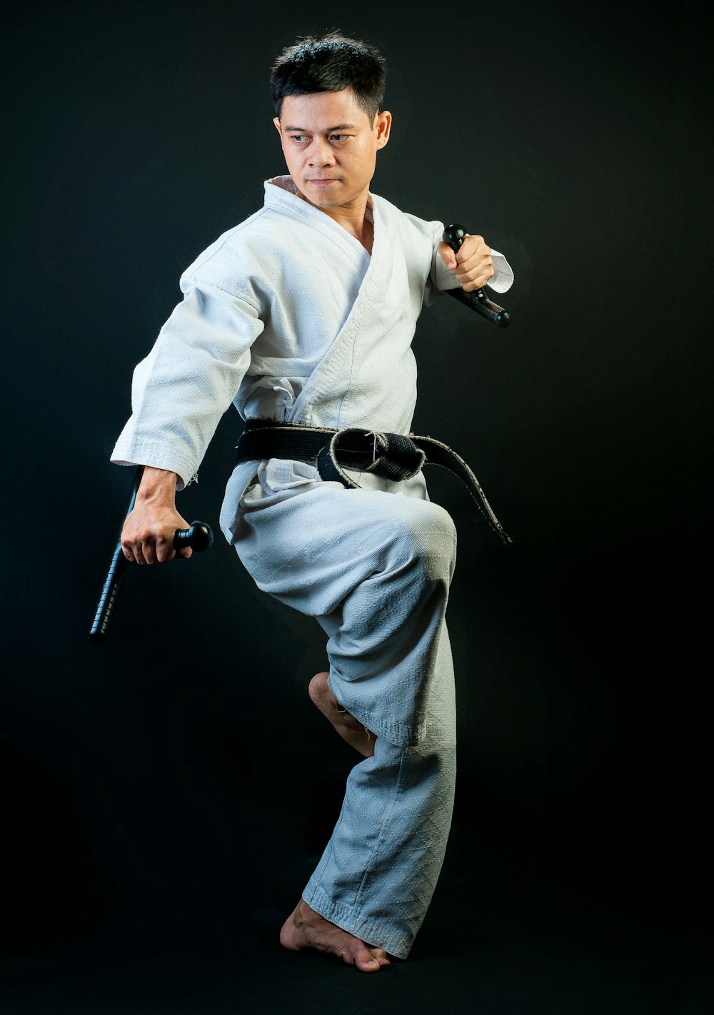 Black belt martial artist standing with one leg