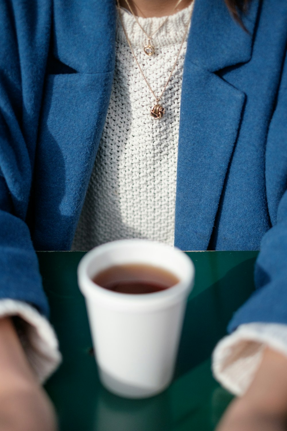 woman in blue suit jacket and white knit top