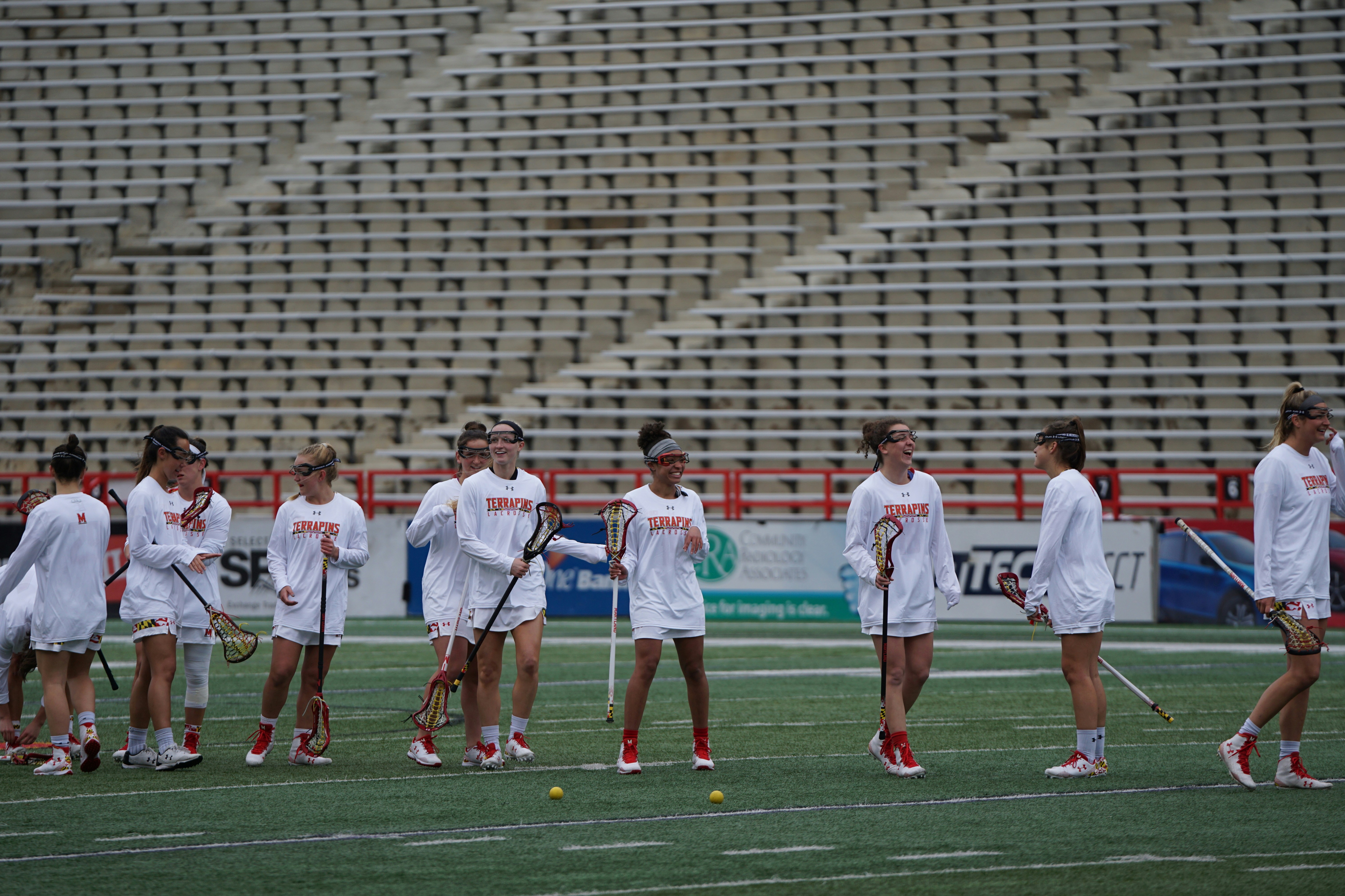 sekelompok wanita bermain lacrosse di siang hari