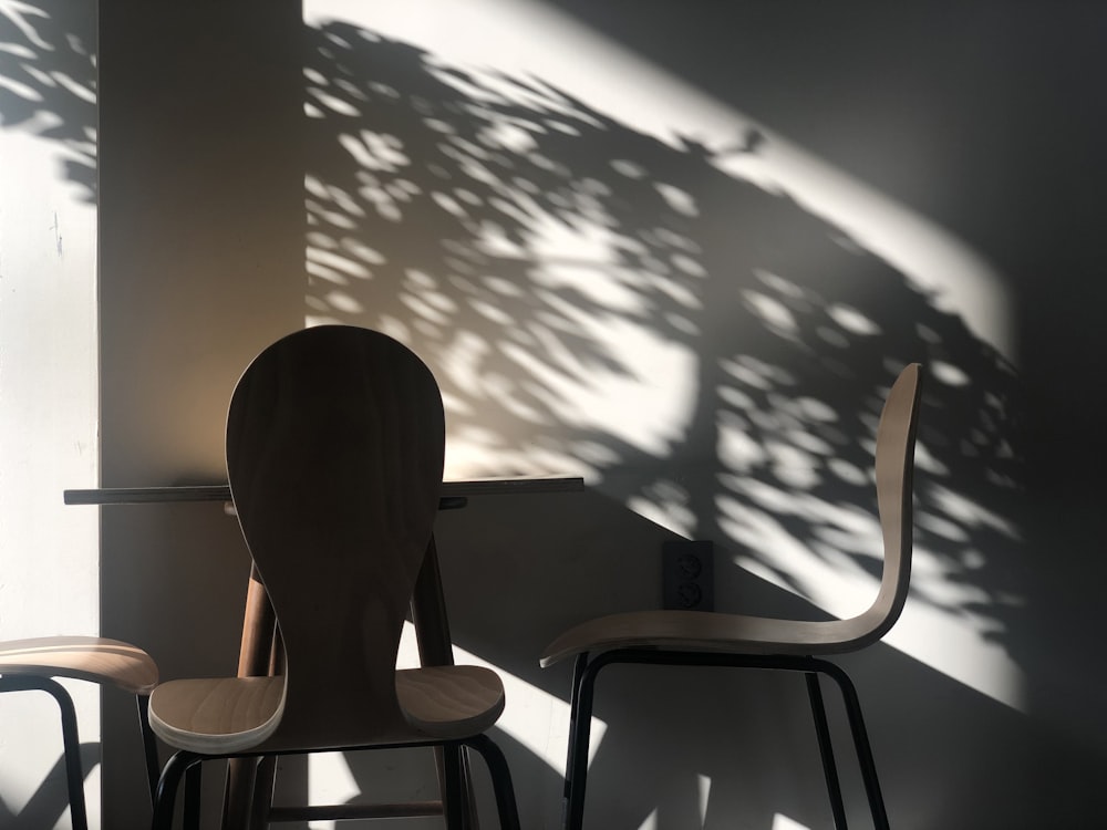 brown wooden table beside three brown chairs