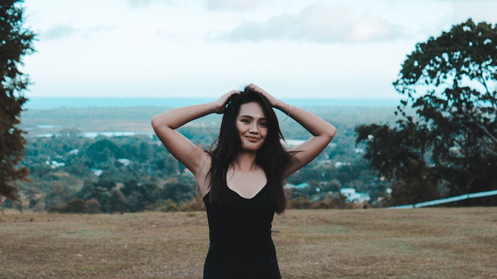 Mulher sorridente em pé no campo marrom