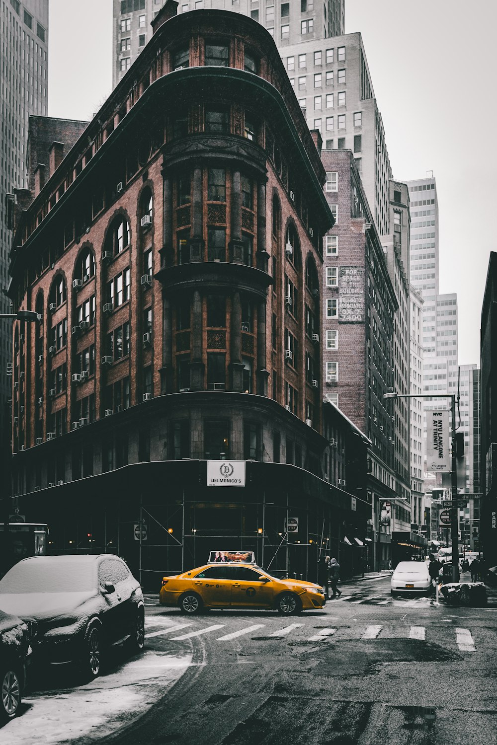 a yellow taxi cab driving down a street next to tall buildings