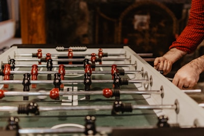 person playing foosball table
