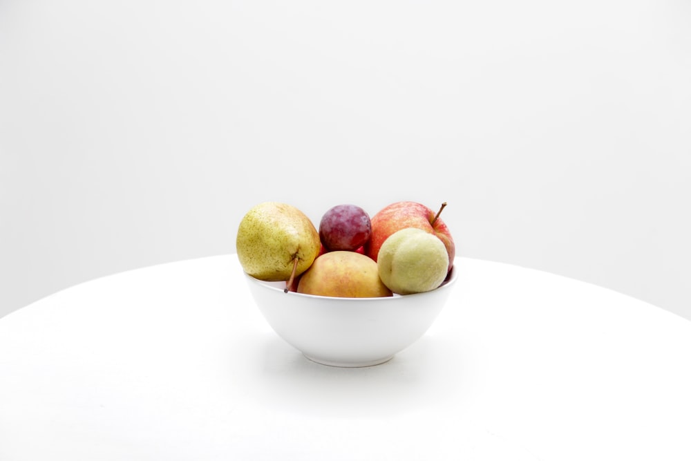 Fruits de couleurs assorties sur un bol en céramique blanche