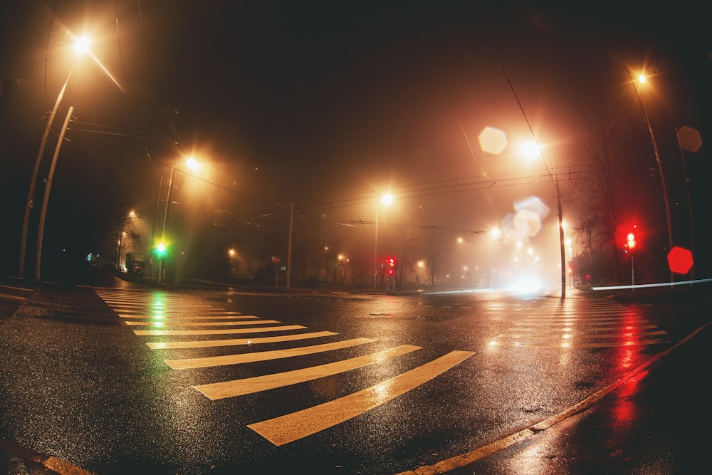 asphalt road with post light during night time