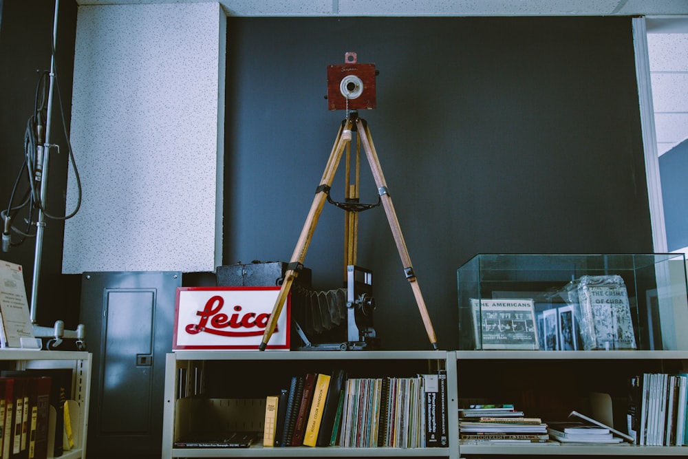 brown and red wooden tripod on white wooden bookcase