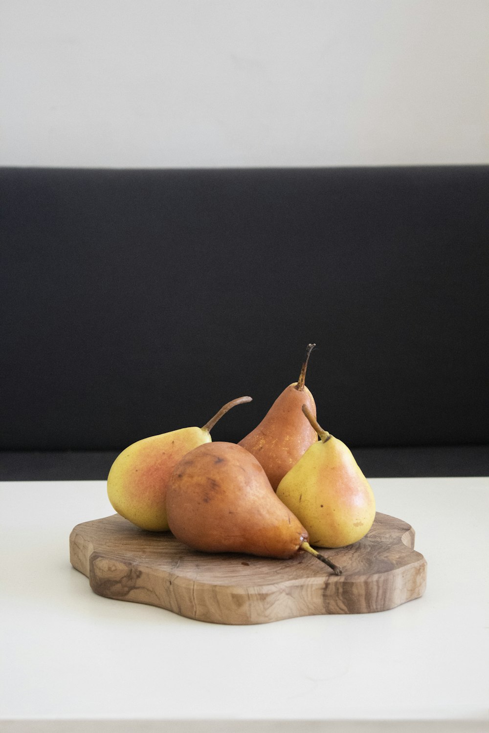 cuatro frutas de peras naranjas en un panel de tablero de madera marrón