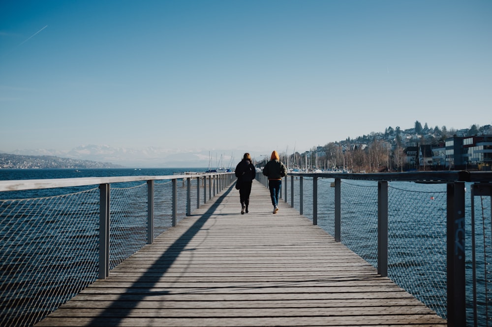 two women standing on beach dock