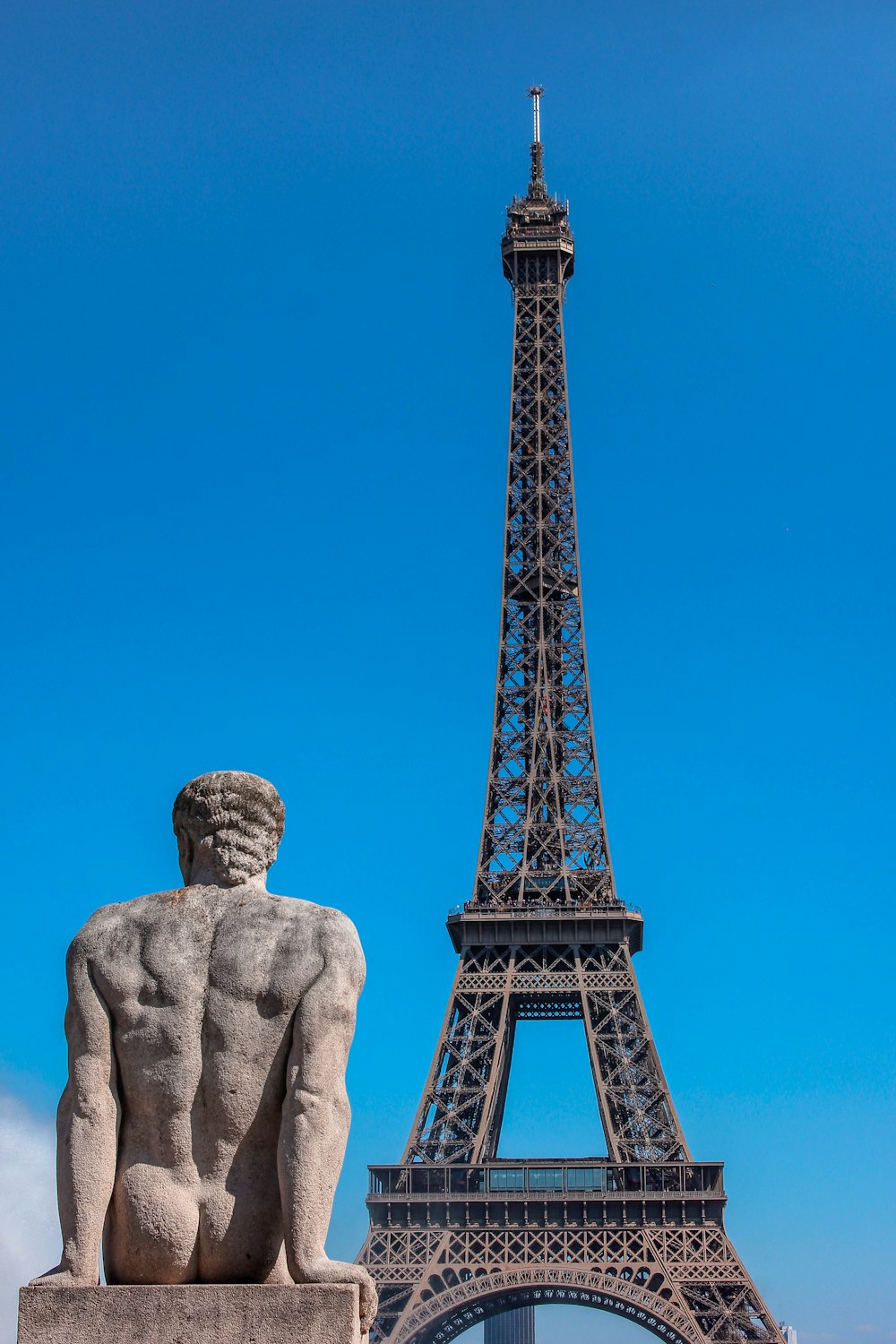 man's sculpture and Eiffel Tower