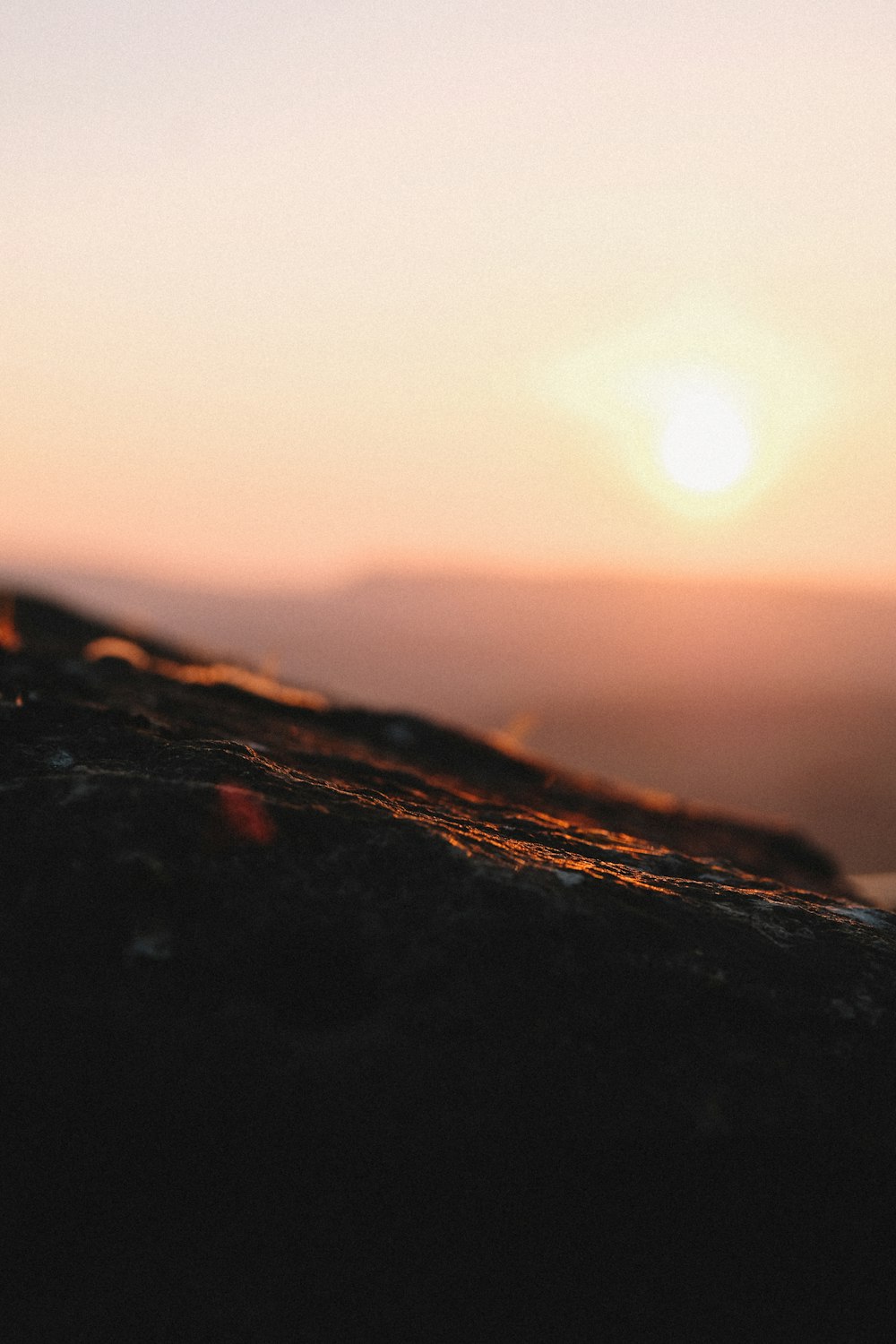 a blurry photo of the sun setting over a mountain