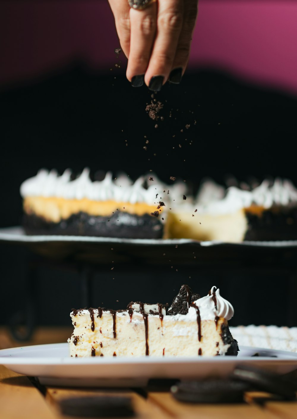 person pouring chocolate powder on baked cake