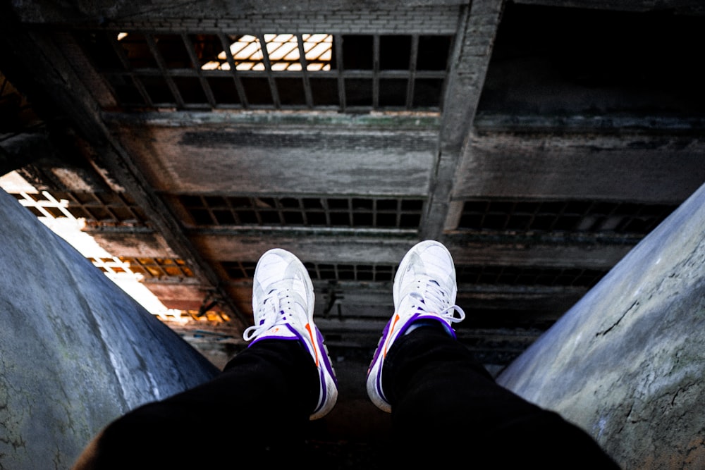 a person wearing white sneakers standing in a room