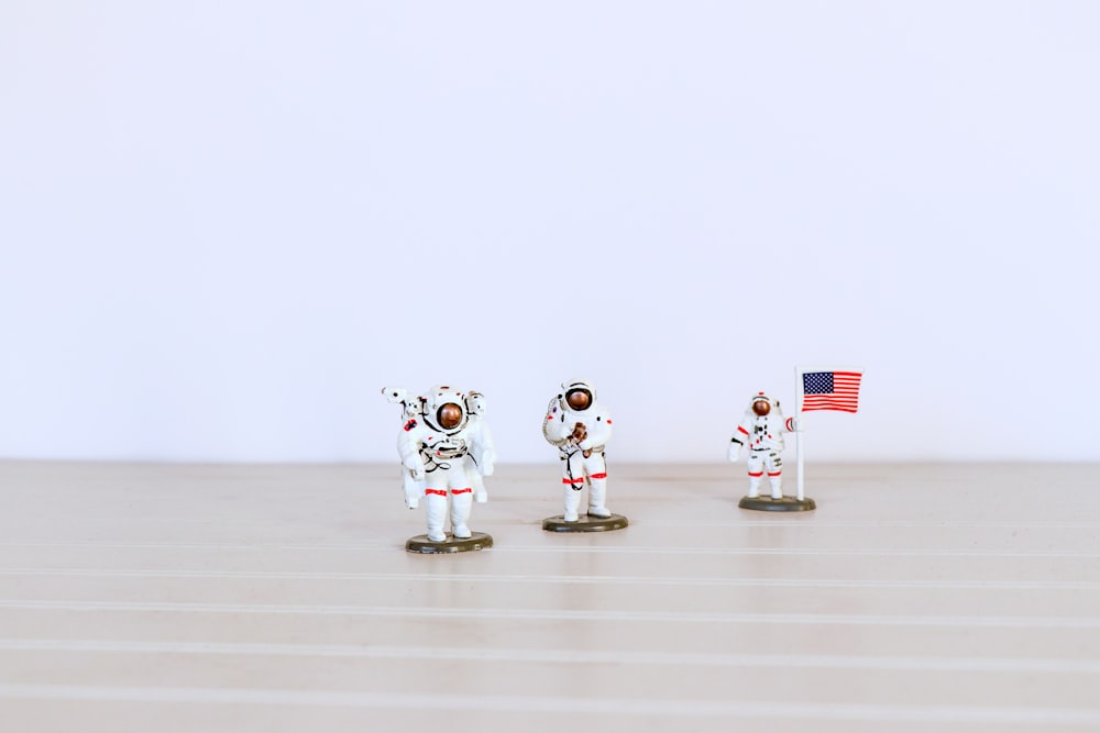 회색 표면에 있는 세 명의 우주 비행사 형상