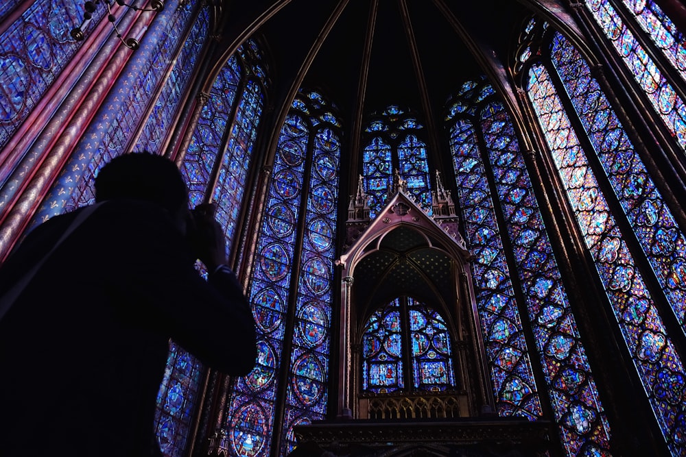 silhouette of person holding camera taking picture cathedral interior