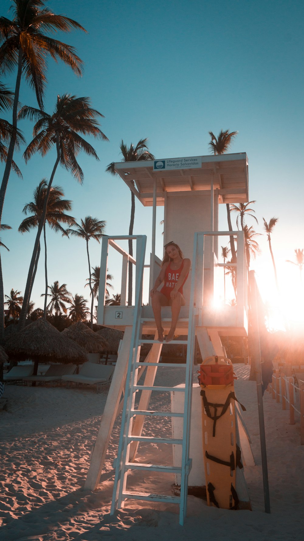 woman sitting on lifeguard house