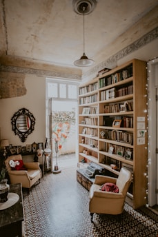 brown fabric sofa chair beside brown bookcase