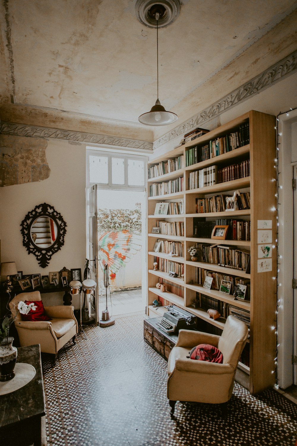 brown fabric sofa chair beside brown bookcase