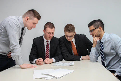 Business professionals reviewing merger documents in a conference room.